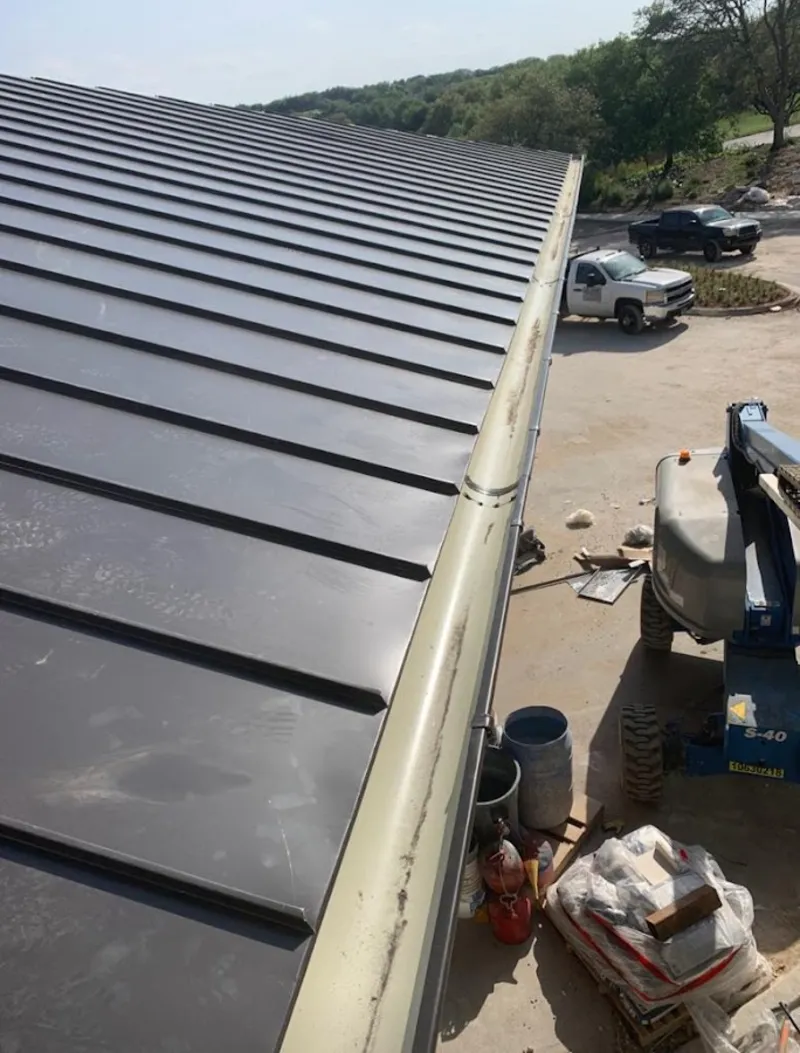 Standing seam panel and gutter detail on a metal roofing jobsite in Jackson